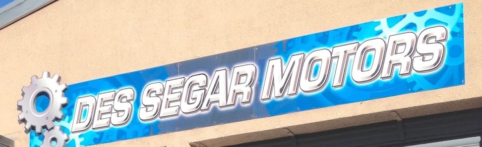 The chrome and blue Des Segar Motors sign above the workshop